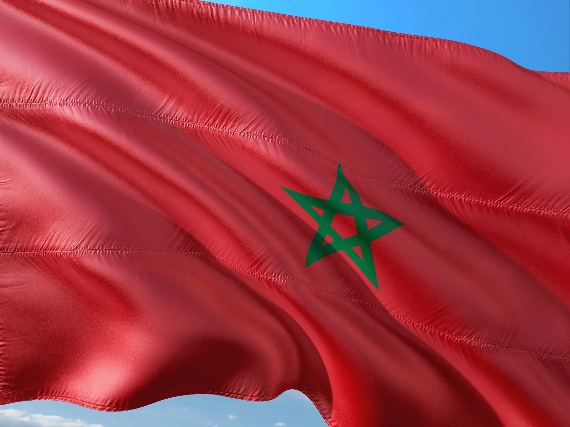 Moroccan flag waving over traditional buildings